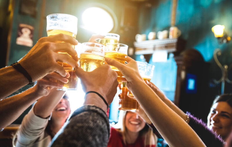 beercheers Group of happy friends drinking and toasting beer at brewery bar restaurant - Friendship concept with young people having fun together at cool vintage pub - Focus on middle pint glass - High iso image
