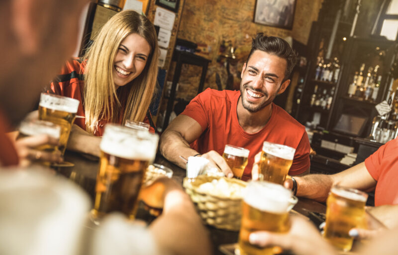 Happy friends group drinking beer at brewery bar restaurant - Friendship concept with young people enjoying time together and having genuine fun at cool vintage pub - Focus on guy - High iso image